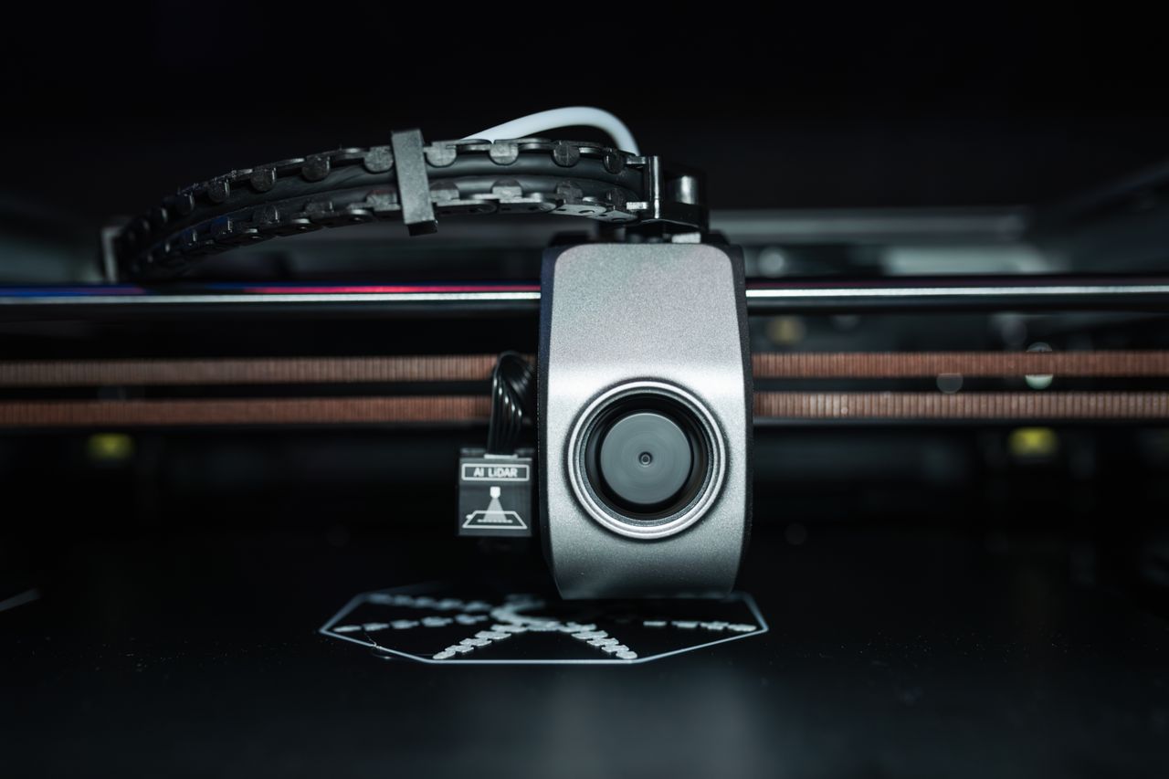 About Detailed close-up of a 3D printer extrusion head in focus, showcasing modern technology.